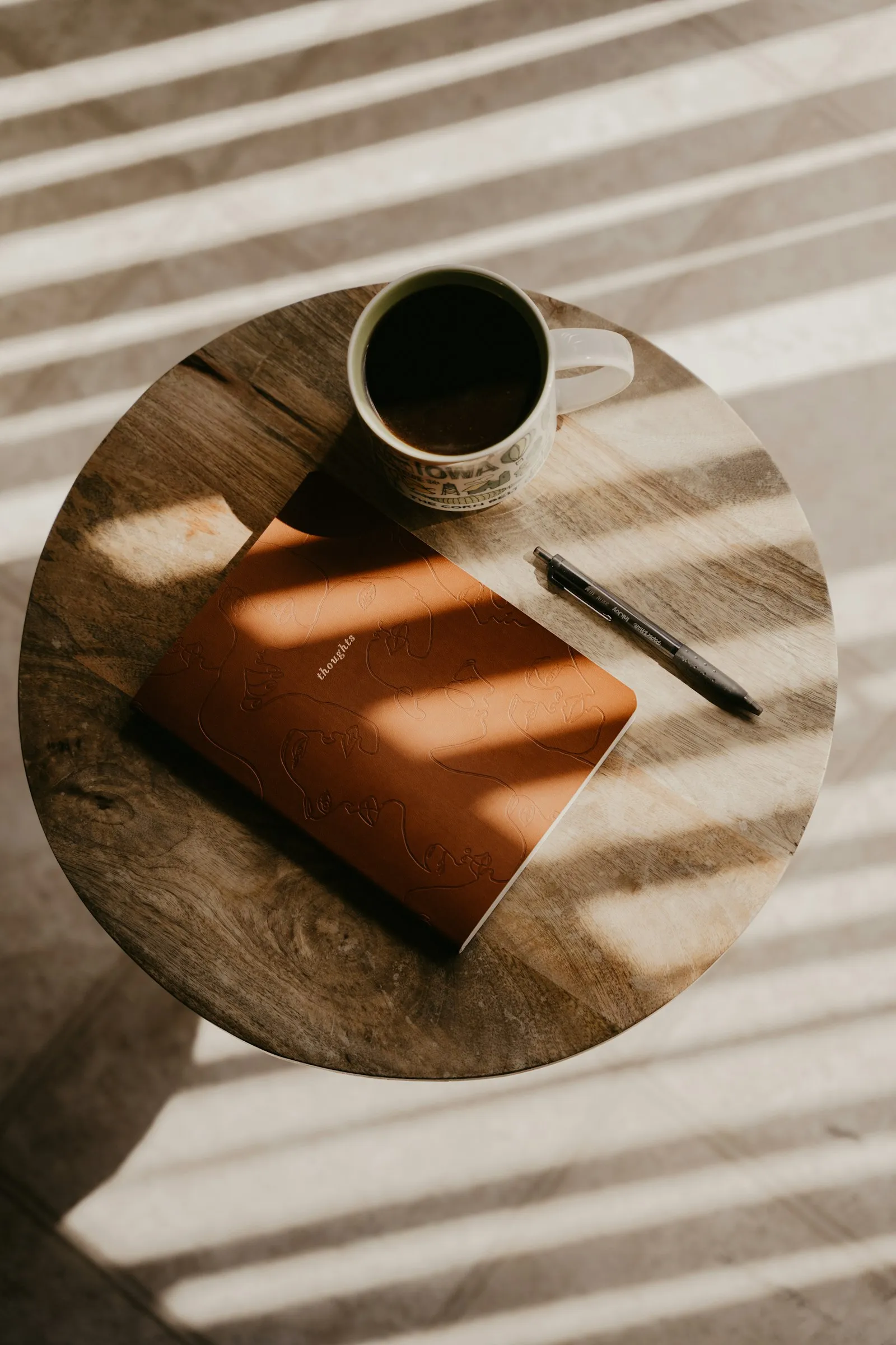 A journal and pen on a table in morning light