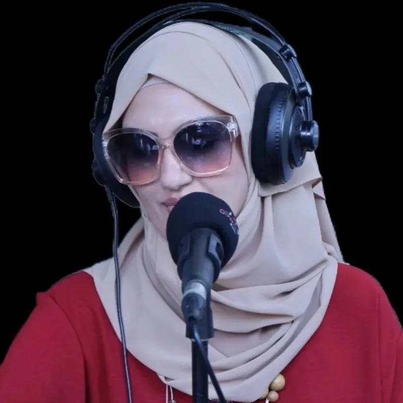 Razia on air at the microphone, headphones on