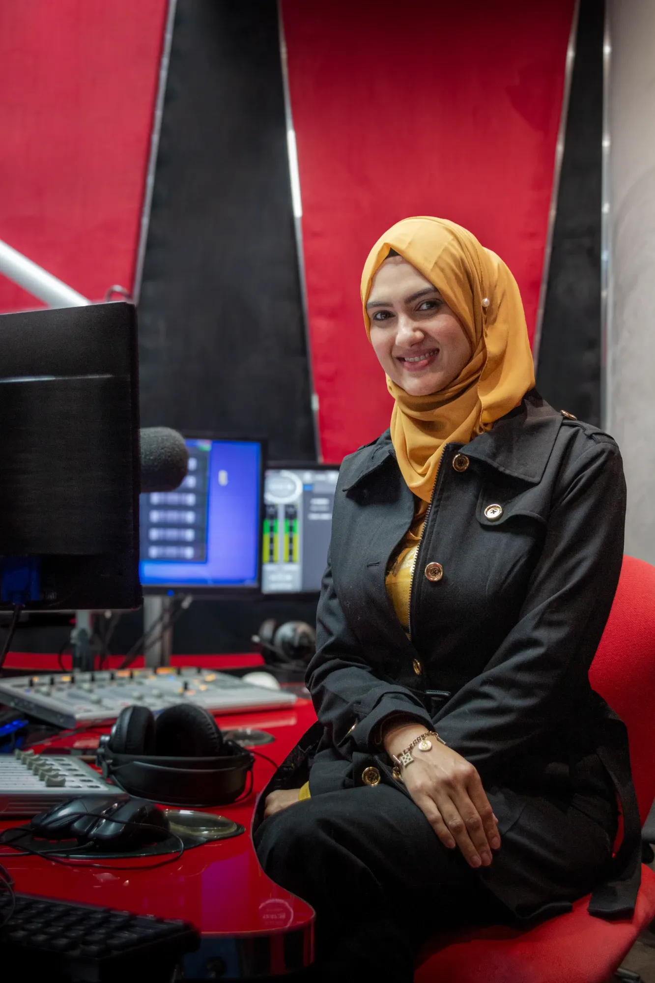 Razia Rangrage smiling in the Radio Al-Ansaar studio